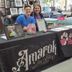 Two women sit at a table for Amarok and 4 Luv of Dog Rescue
