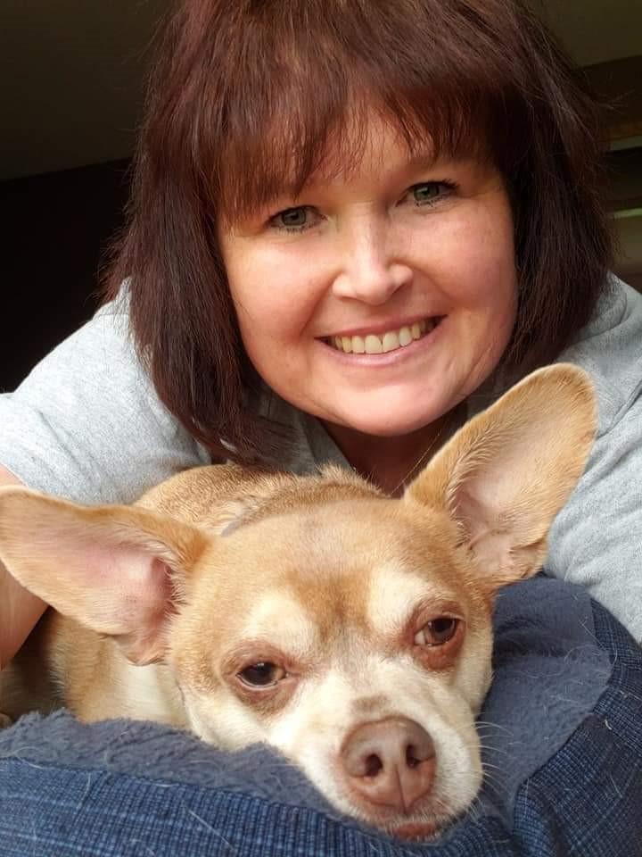 A woman takes a selfie with a chihuahua with very big pointy ears.